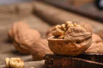 Walnut kernels and whole walnuts on rustic old oak table.