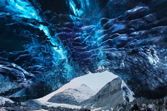 Blue crystal ice cave and an underground river beneath the glacier. Amazing nature of Skaftafell, Iceland. Photography inside of the glacier. Vatnajokull National Park, Iceland.