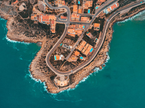 Beautiful mediterranian coastline near Valencia, Spain with small town, hotels, buildings and roads. Autumn winter blue turquoise cold sea water and warm colors coastline. Aerial drone shot view