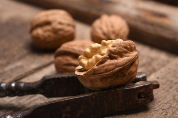 Walnut kernels and whole walnuts on rustic old oak table.