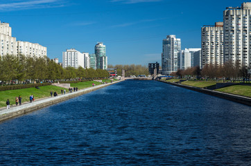 Naklejka premium Perspective of the city river channel. The pedestrian embankment of the Smolenka River. Vasilievsky Island. Sunny spring weather. St. Petersburg, Russia, 1 May 2018