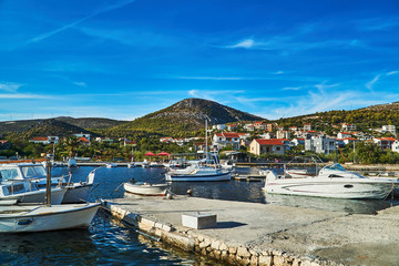 Fototapeta na wymiar Boats and sailboats in the marina in the city of Seget Vranjica in Croatia.