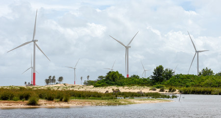 Fototapeta na wymiar Windmills on the sand dunes of Lencois Maranhenses near Atins, Brazil