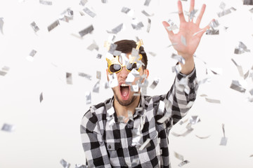 People, holidays and party concept - Man with funny face in plaid shirt with confetti
