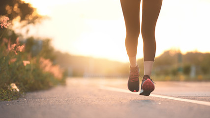 Young fitness sport woman running on the road in the morning, Sun light flare