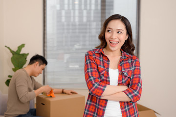 Young couple decorate their new apartment.Woman standing in front of camera.