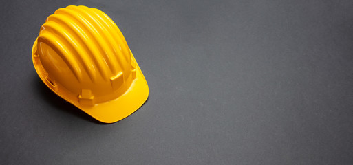 Construction project safety, Yellow hard hat on black color background, copy space