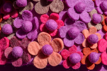 Background of hand made vivid coloured wool felt flowers