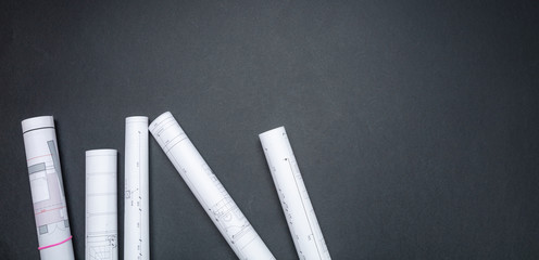 Construction project concept. Architecture Blueprint rolls on black background, copy space