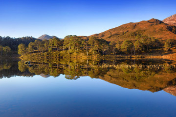 Fototapeta premium Autumn panorama of Loch Claire with the views of Beinn Eighe and Liathach from across the water. Glen Torridon, Highlands, Scotland, UK Beautiful landscape reflection in water 