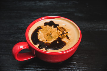 fresh aromatic coffee in a red mug on a black wooden background