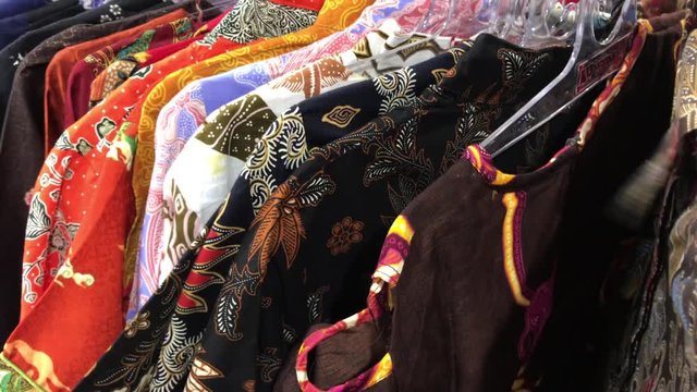 Batik men shirts in the store. Shopping mall. Male shopping concept. 4K video of colorful fashion men clothes.