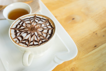 hot coffee late in white glass on wooden table,