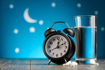 Alarm clock, pills and glass