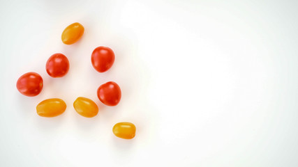 Fototapeta na wymiar Pomidorki koktajlowe. Czerwone i pomarańczowe leżące na białym tle