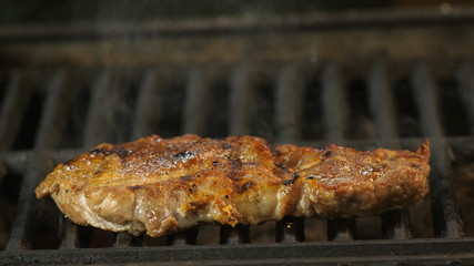Large steak fried on the grill, side view, close-up shot