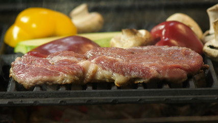 Slow motion of steak, cooking steak with grilled vegetables