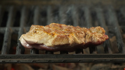 Grilled steak close-up in the background of smoke, juicy large piece of beef or veal grilled, restaurant dish, delicacy, close-up video
