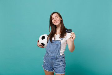 Pensive young woman football fan support favorite team with soccer ball, credit bank card, looking...
