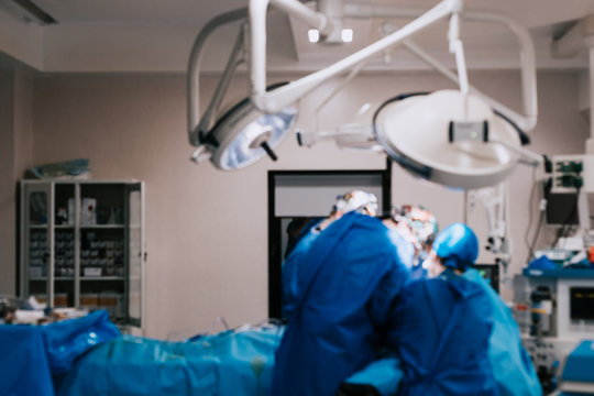Blurred image of team of surgeons performing surgery in hospital sterile environment