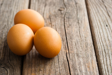 three eggs on weathered wooden table