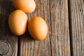three eggs on weathered wooden table