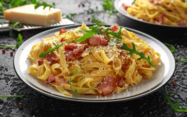 Classic Carbonara pasta, spaghetti with pancetta, bacon, egg, parmesan cheese and green arugula.