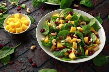 Mango Spinach salad with dried cranberries and nuts. healthy food.