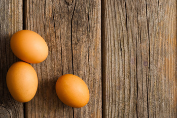 three eggs on weathered wooden table