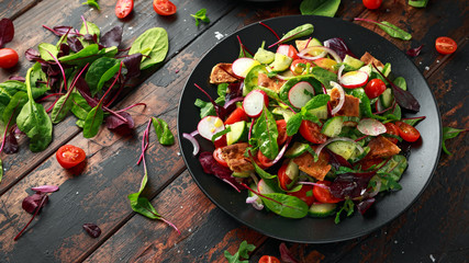 Traditional fattoush salad on a plate with pita croutons, cucumber, tomato, red onion, vegetables...