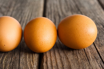 three eggs on weathered wooden table