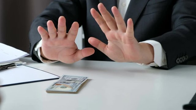 Businessman rejecting money cash banknote from business people. honest man refuse to take the bribe. Close up