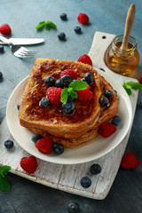 French cinnamon toast with blueberries, raspberries, maple syrup and coffee. morning breakfast