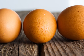 three eggs on weathered wooden table