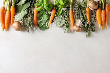 Fototapeta na wymiar Variety of fresh kitchen herbs with mini carrots and champignon mushrooms in row over white marble background. Flat lay, space. Cooking concept, food background.