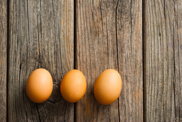 three eggs on weathered wooden table