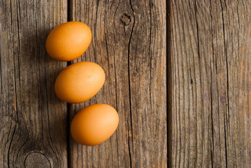three eggs on weathered wooden table