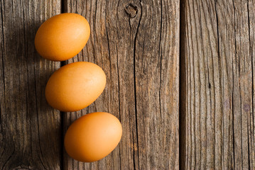 three eggs on weathered wooden table