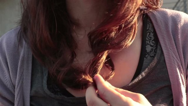 girl touches nervously her hair, detail of finger movement