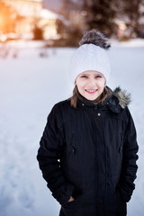 A teen girl shows that she is cold from wind and frost at the end of winter. Vertical