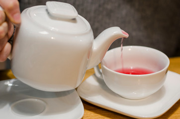 Pouring red tea into a cup