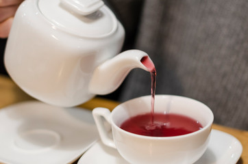 Pouring red tea into a cup