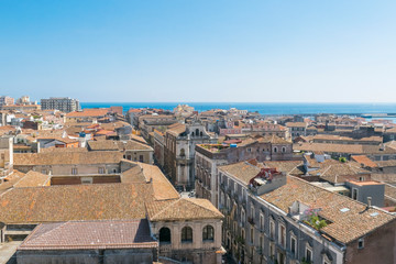 Naklejka premium Aerial skyline panoramic view of city of Catania in September, old town featuring brown, ochre and yellow roofs. Sicily, Italy. Vintage or travel background.
