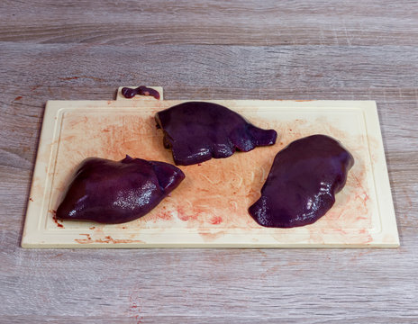 Three pieces of fresh liver on a cutting board