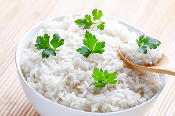 Bowl with white boiled rice with green fresh parsley for delicious healthy lunch. Cereal food and dishes.