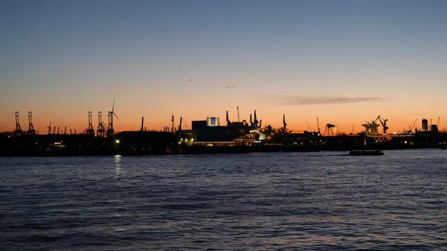 stage Theater im Hafen at dusk with spectacle Mary Poppins and industrial pipes gas and oil factories in background