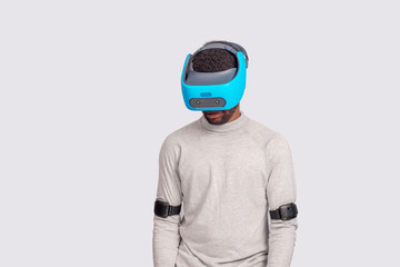 Virtual Reality headset on a black male with video game controllers over white background. Man looking down through vr glasses.