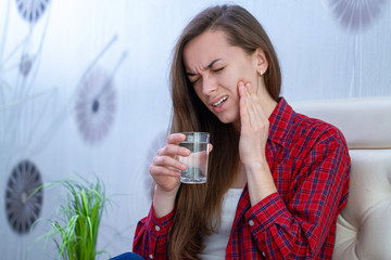 Young woman suffering and experiencing strong aching toothache. Tooth decay and sensitivity....