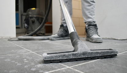  man vacuums the floor after repairs