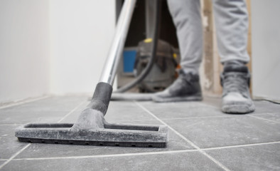  man vacuums the floor after repairs